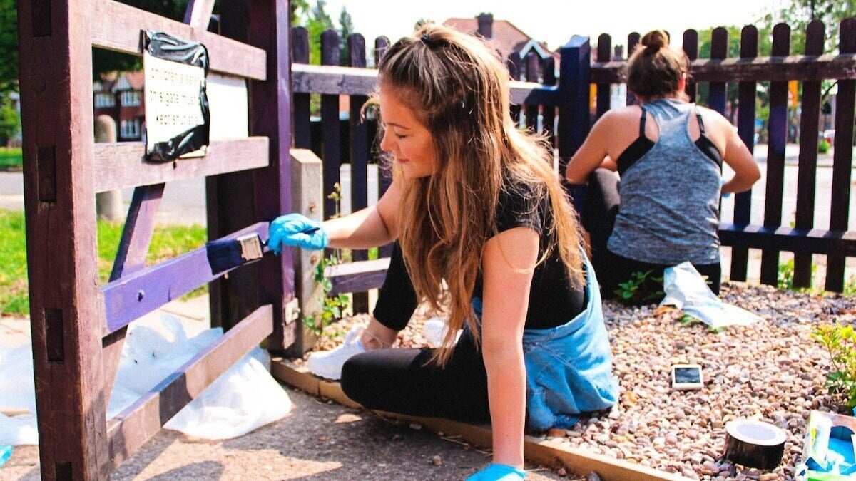 RGER employee painting a fence